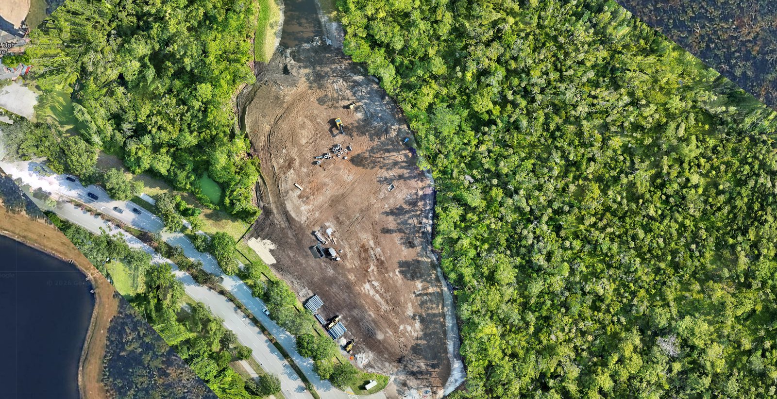 2D orthomosaic of active construction site showing cleared building pad, equipment, and material staging